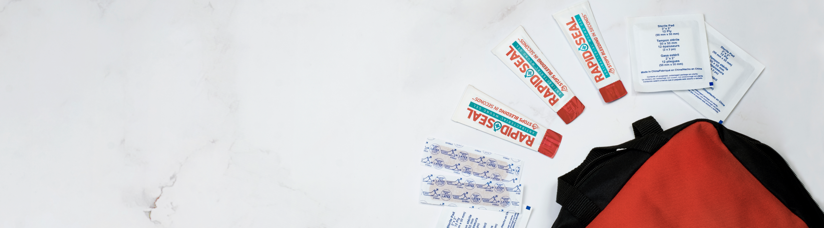 picture of a first aid kit with rapid seal pakcets and bandages coming out of it as well as gauze pads